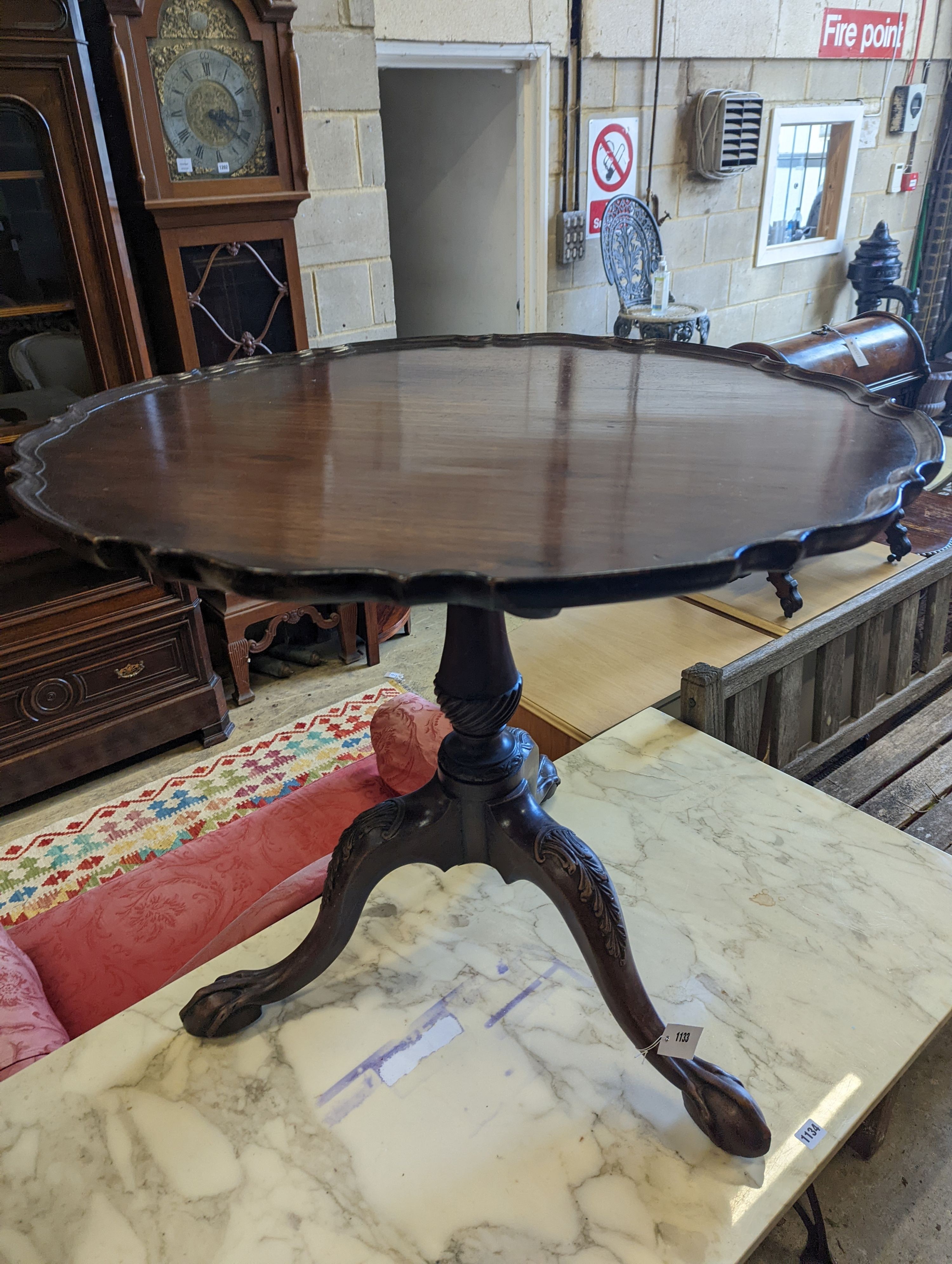 A George III style circular mahogany tripod table, with piecrust top and claw and ball feet, diameter 75cm, height 70cm